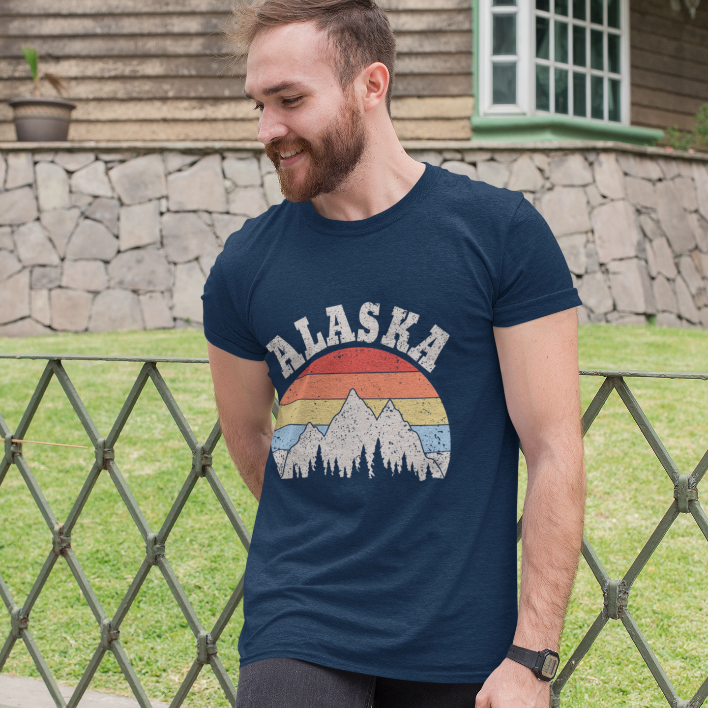 Man wearing a navy blue t-shirt with 'Alaska' design outdoors.