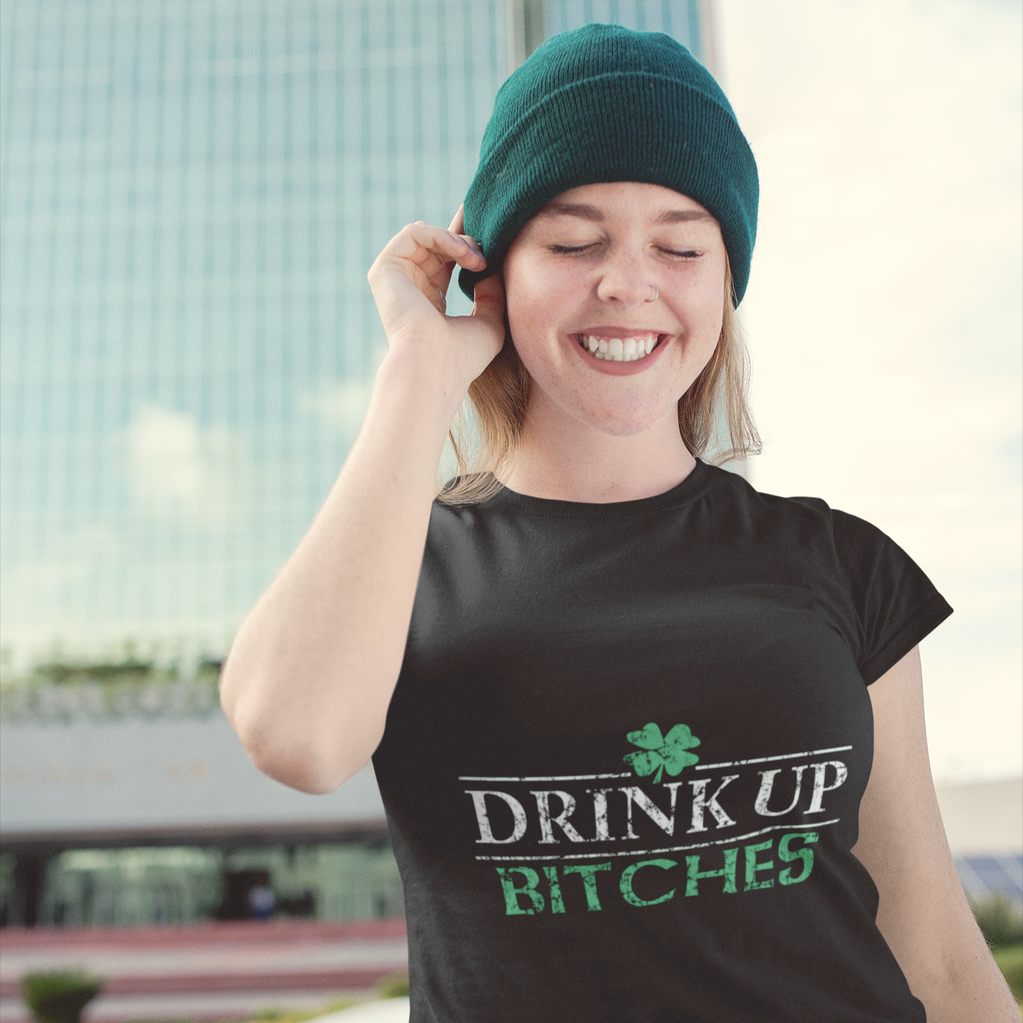 Person wearing a black t-shirt with 'DRINK UP BITCHES' text, standing outdoors.