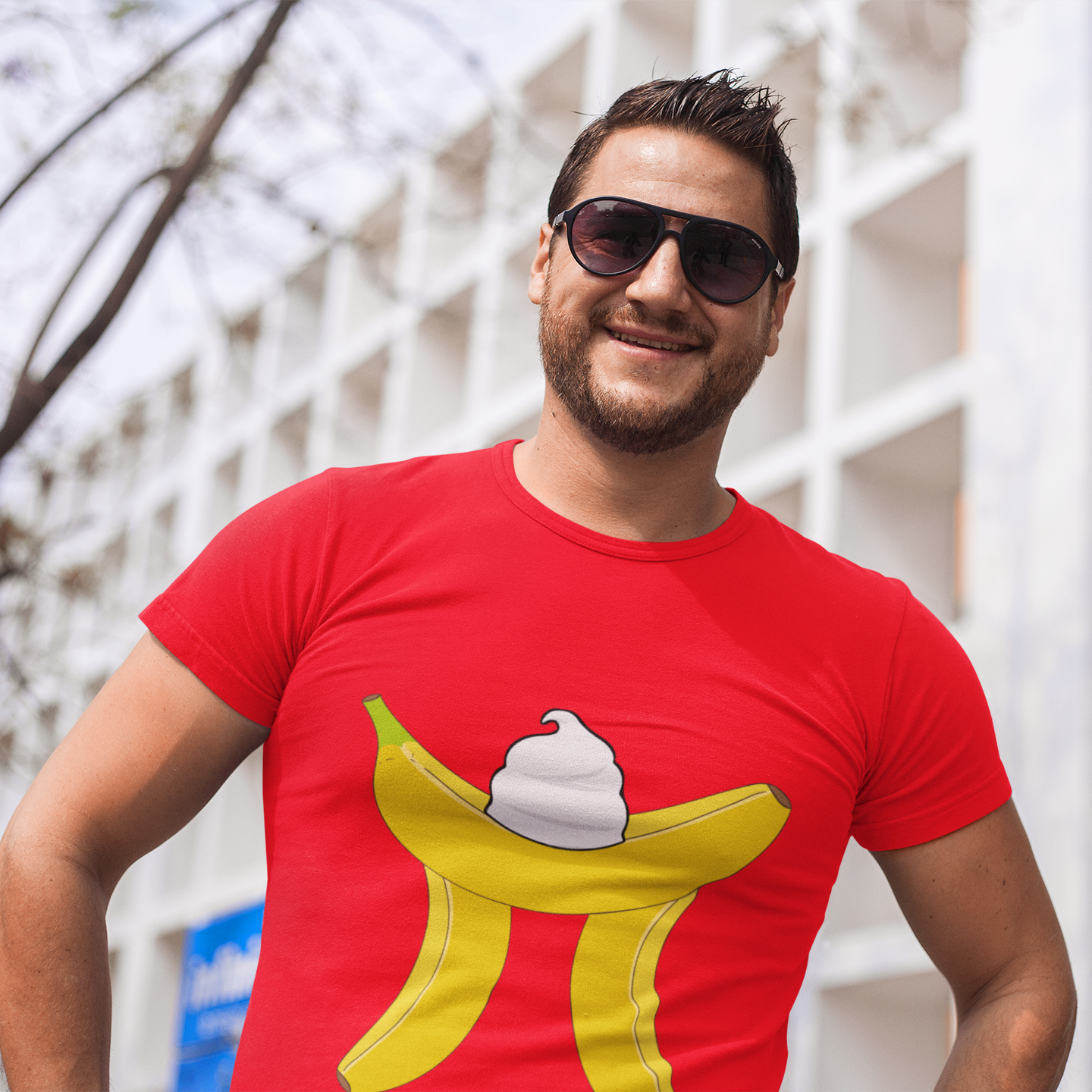 Man wearing a red t-shirt with a banana ice cream design, standing outdoors.
