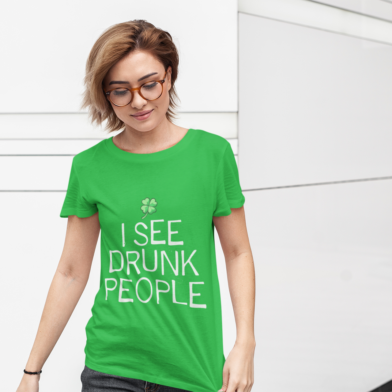 Person wearing a green t-shirt with 'I See Drunk People' text against a white wall.