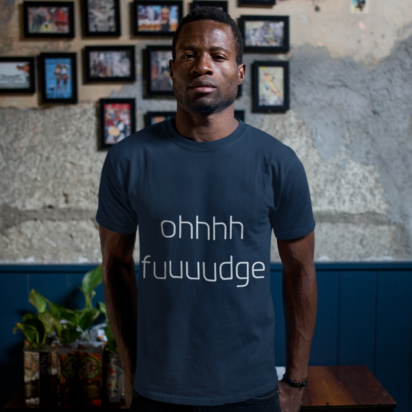 Man wearing a navy blue t-shirt with text in a casual setting