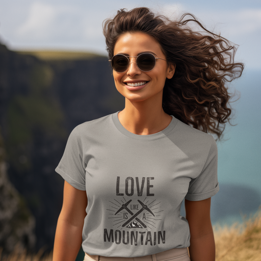 Woman wearing a t-shirt with 'Love is the Mountain' design outdoors.