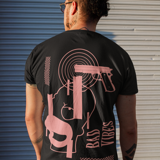 Person wearing a black t-shirt with pink graphic design against a metallic shutter background