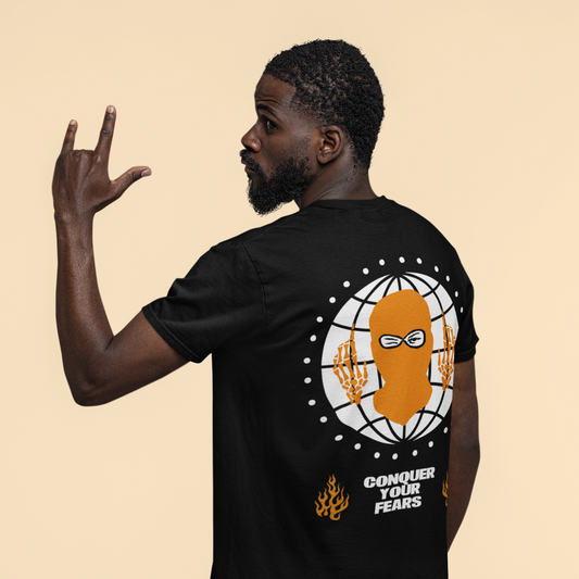 Person wearing a black t-shirt with a graphic design and text on the back, against a beige background