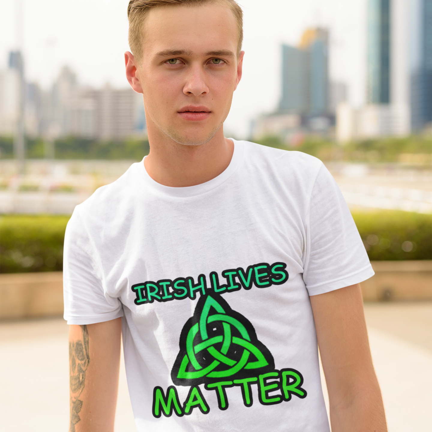 Person wearing a white t-shirt with 'Irish Lives Matter' design in front of a cityscape.