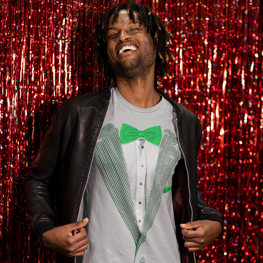 Person wearing a gray t-shirt with a green bow tie graphic against a red glittery background