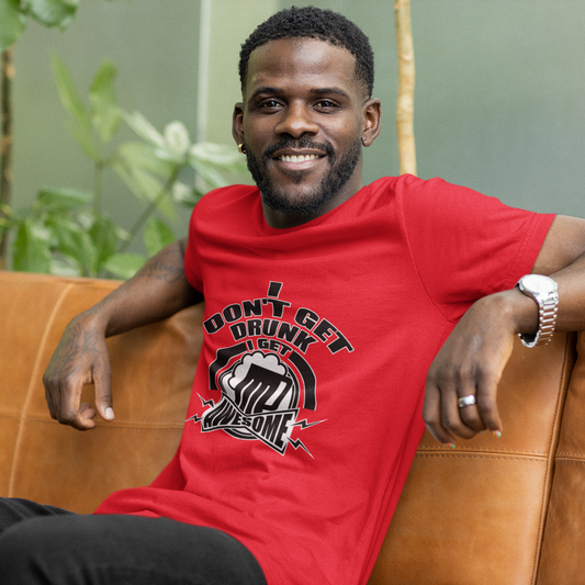 Man wearing a red t-shirt with text and graphics, sitting on a brown couch with a blurred green background