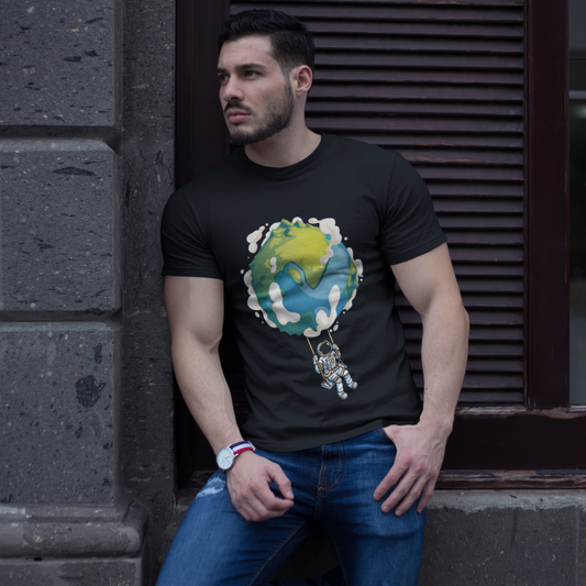 Man wearing a black t-shirt with a colorful graphic design, leaning against a stone wall.