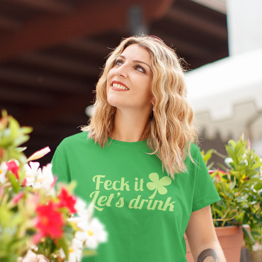 Woman wearing a green t-shirt with text, sitting outdoors with flowers and plants around.