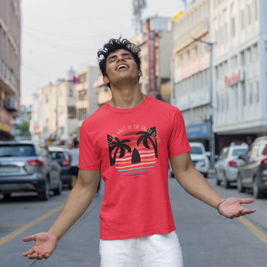 Man wearing a red t-shirt with a palm tree design on a city street.