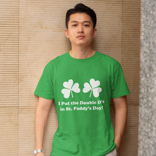 Man wearing a green t-shirt with shamrock design and text against a textured wall.
