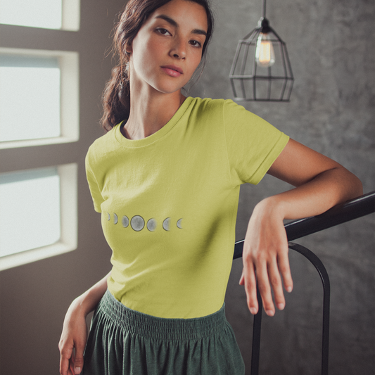 Woman wearing a green t-shirt with a graphic design, standing indoors.