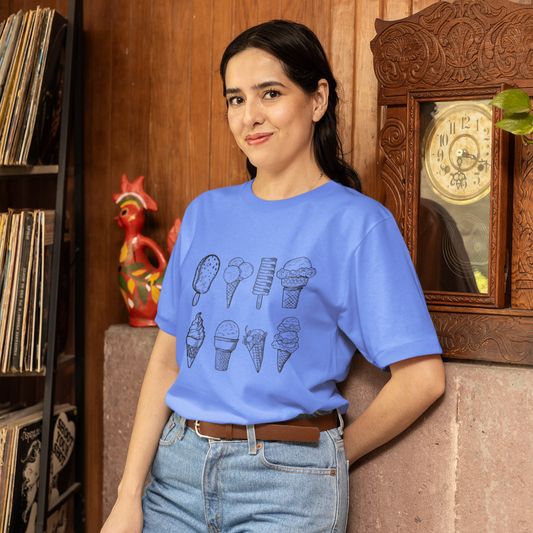 Woman wearing a blue t-shirt with ice cream cone designs in a room with wooden walls and decorative items.