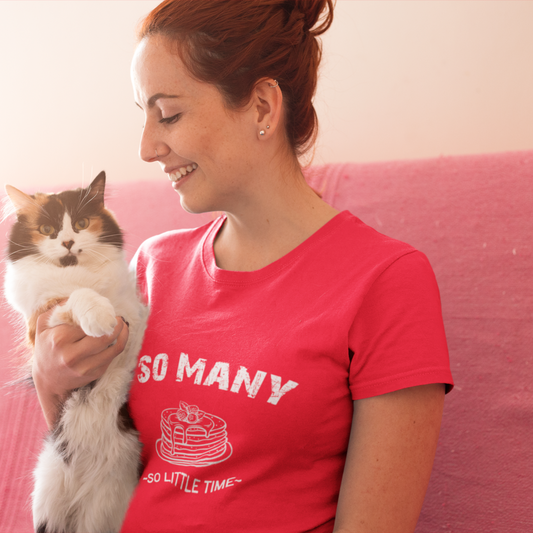 Woman in a pink t-shirt holding a cat on a pink couch
