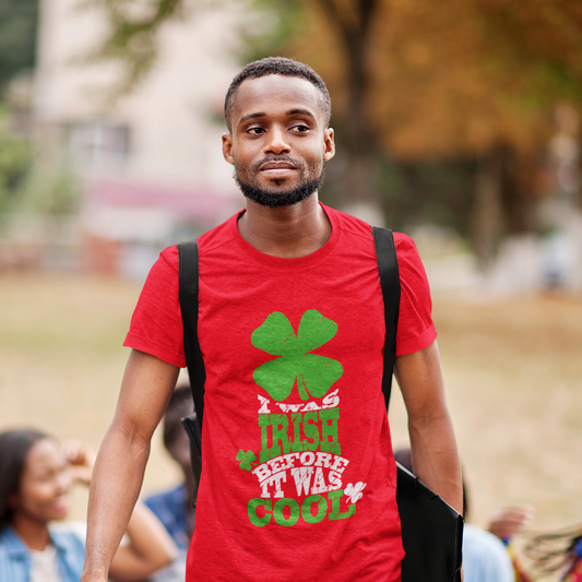 Man wearing a red t-shirt with a shamrock design and text, standing outdoors.