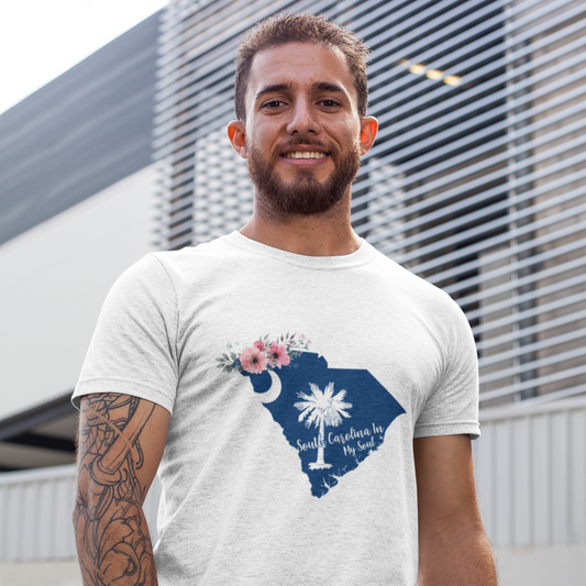 Man wearing a white t-shirt with a blue graphic design of South Carolina, standing in front of a modern building.