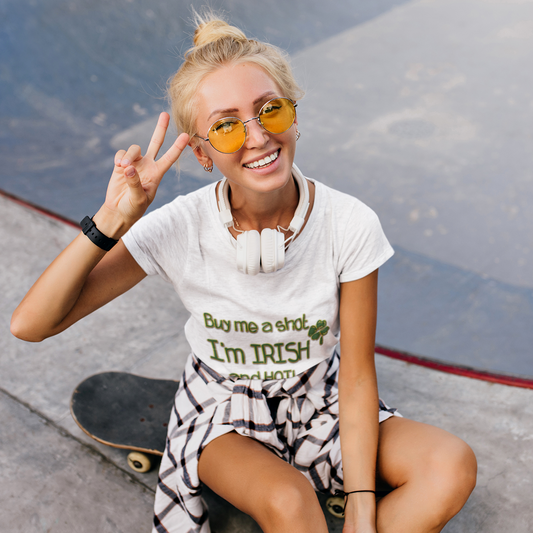 Woman sitting on a skateboard at a skate park, making a peace sign