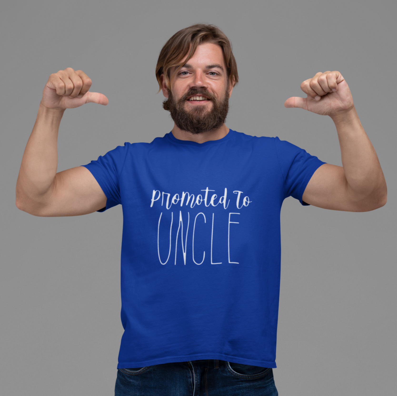 Man wearing a blue t-shirt with 'promoted to UNCLE' text, posing with thumbs up on a gray background