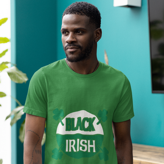 Man wearing a green t-shirt with 'Black Irish' text standing against a teal wall.