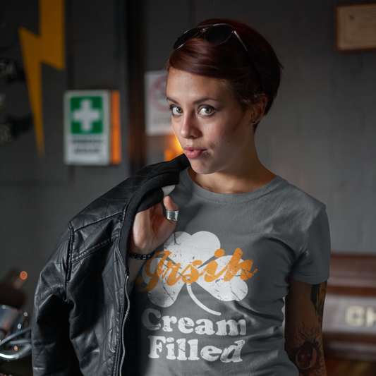 Person wearing a gray t-shirt with 'Irish Cream Filled' text and graphics, standing indoors.