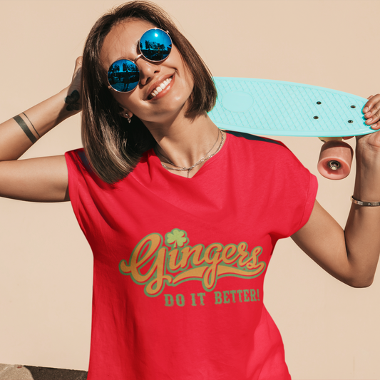 Woman wearing a red t-shirt with 'Gingers Do It Better!' text, holding a turquoise skateboard against a beige background.