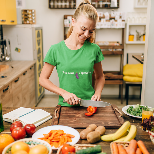 Woman in a green t-shirt preparing vegetables in a kitchen