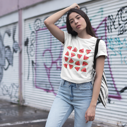 Woman wearing a white t-shirt with red strawberry pattern in front of a graffiti-covered wall.