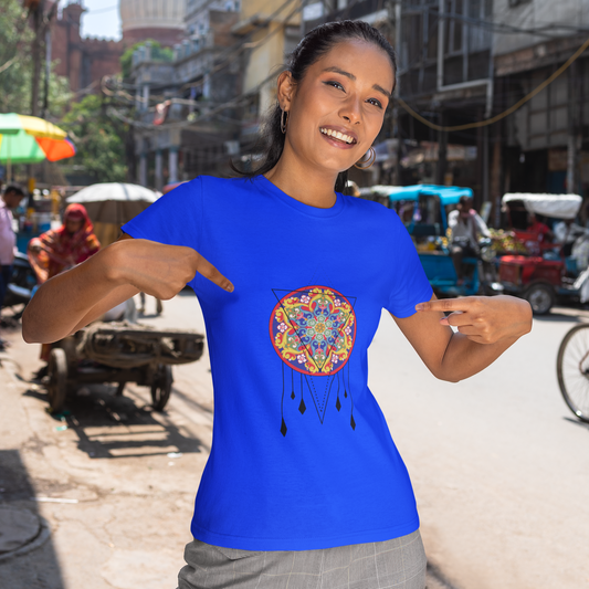 Woman wearing a blue t-shirt with a colorful design on a busy street.