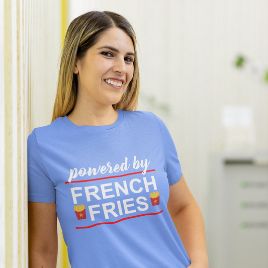 Woman wearing a blue t-shirt with 'Powered by French Fries' text, standing indoors.