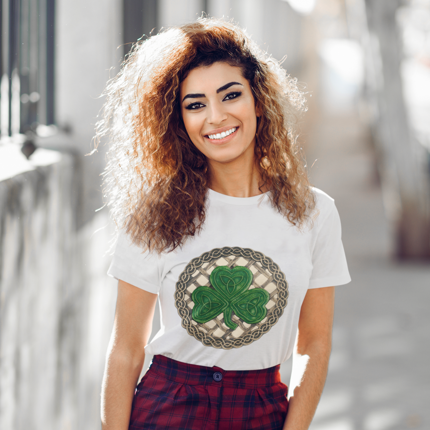 Woman wearing a white t-shirt with a shamrock design outdoors