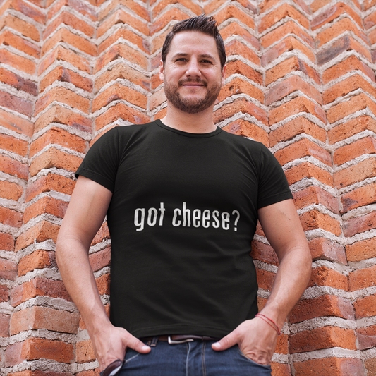 Man wearing a black t-shirt with 'got cheese?' text against a brick wall.