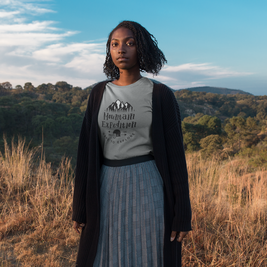 Woman wearing a t-shirt with a mountain design in a scenic outdoor setting