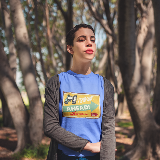 Person wearing a blue t-shirt with a graphic design in a forest setting