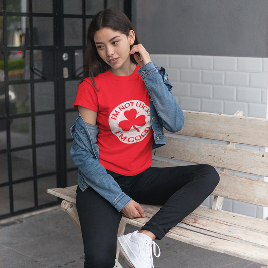 Person wearing a red shirt with a graphic design, sitting on a bench.