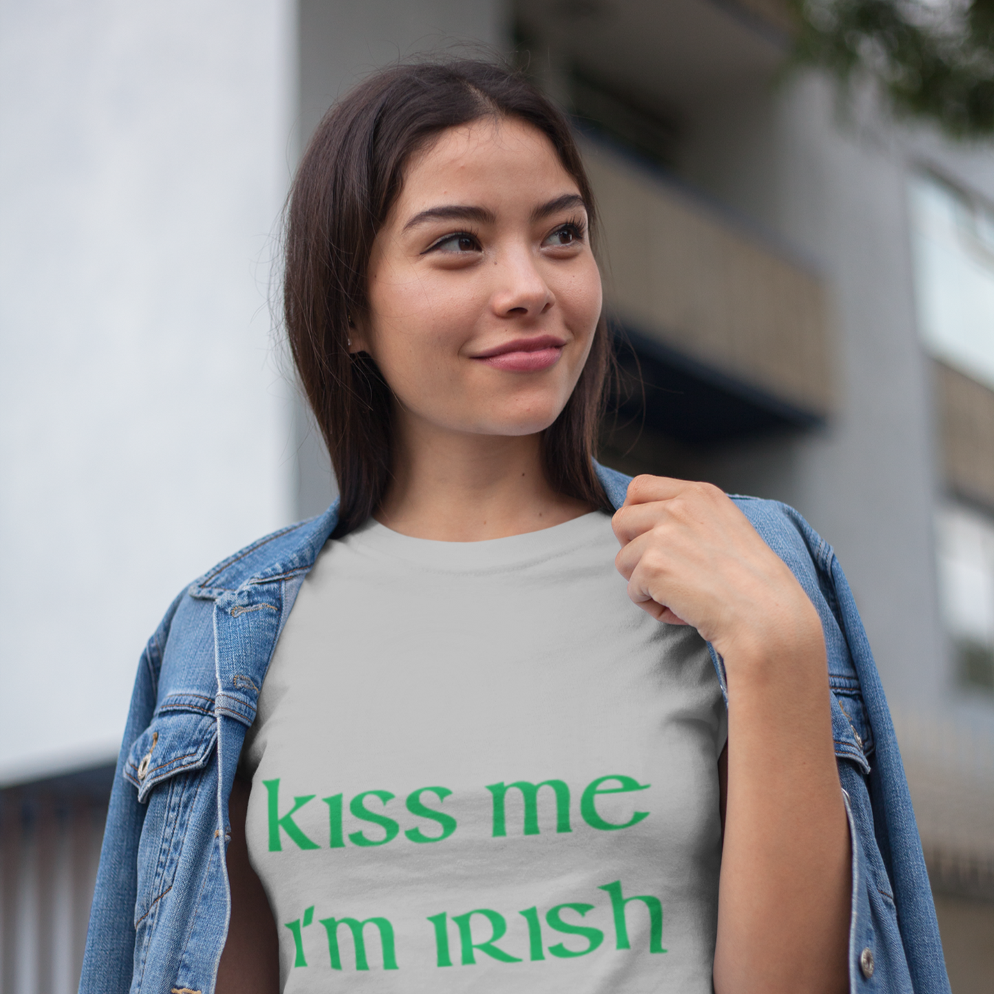 Woman wearing a t-shirt with 'kiss me I'm Irish' text outdoors.
