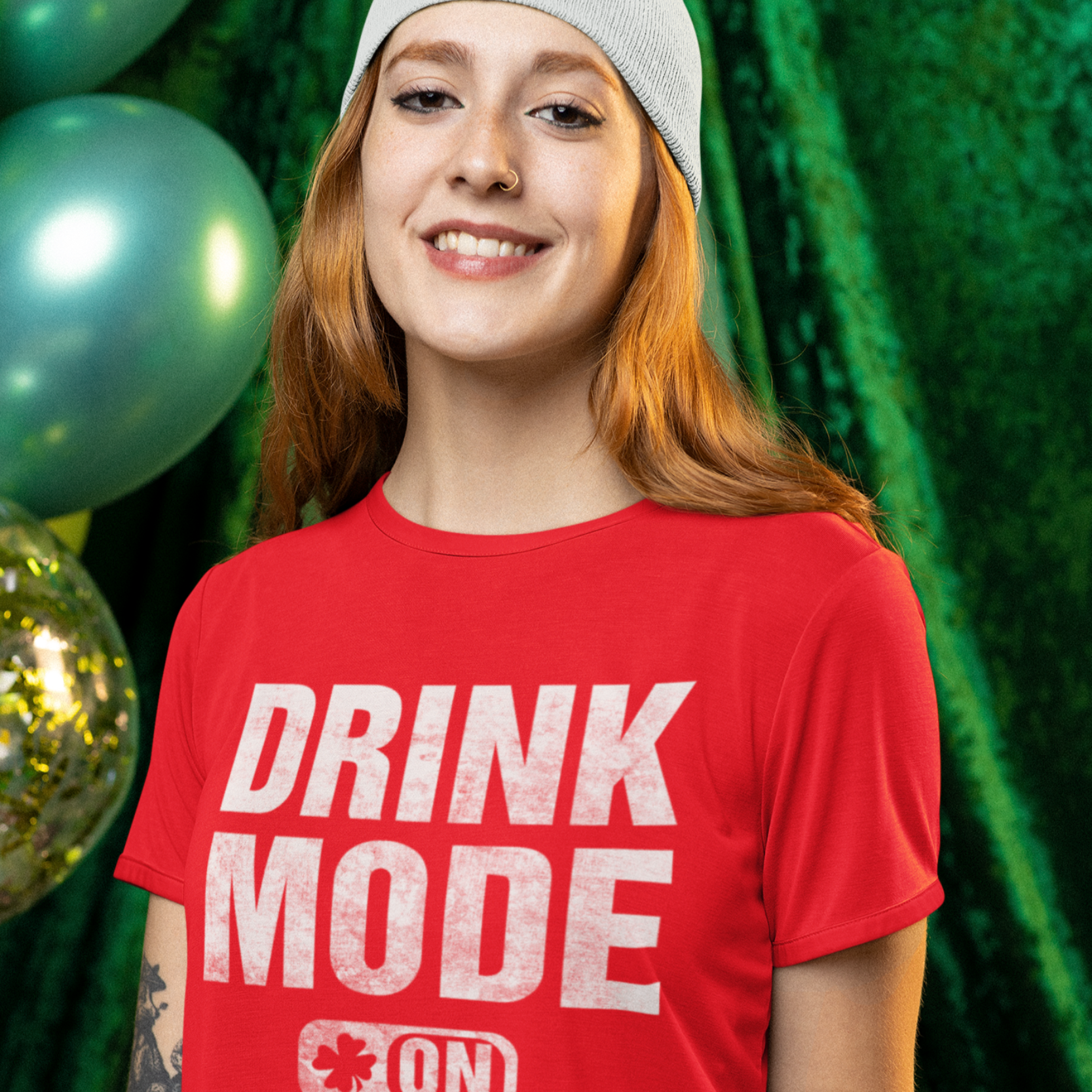 Person wearing a red 'DRINK MODE ON' t-shirt holding a beer mug with a festive background.