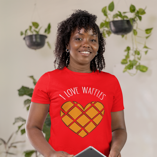 Person wearing a red t-shirt with 'I Love Waffles' design, holding a tablet, in a home setting.