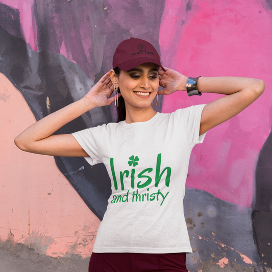 Person wearing a white t-shirt with 'Irish and thirsty' text, standing against a colorful mural.