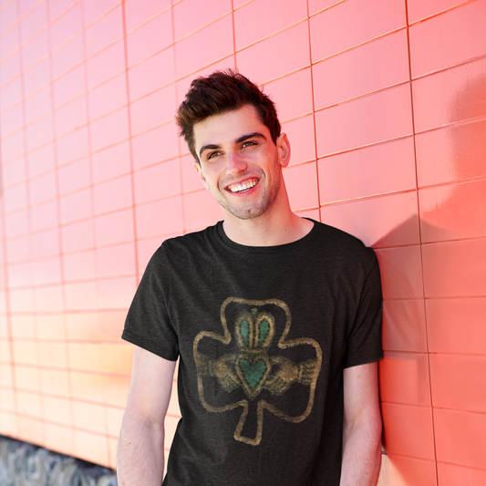 Man wearing a black t-shirt with a shamrock design against a pink tiled wall.