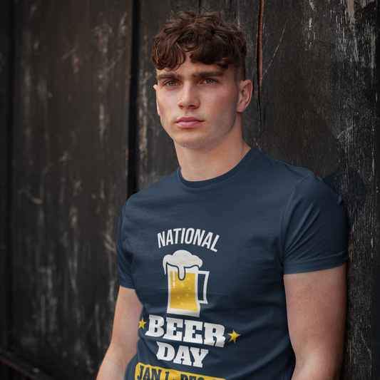 Man wearing a navy blue t-shirt with 'National Beer Day' graphic against a dark textured wall.