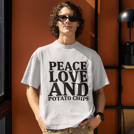 Person wearing a t-shirt with 'Peace Love and Potato Chips' text against an orange wall.