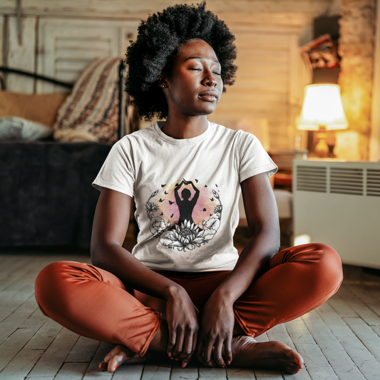 Woman sitting in a meditative pose wearing a t-shirt with a yoga design.