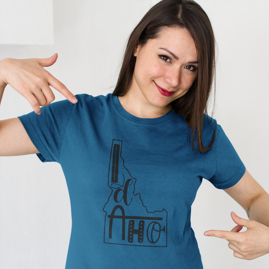 Woman wearing a blue t-shirt with Idaho design, pointing to the shirt.