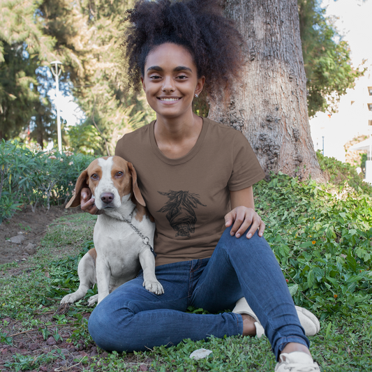 Woman sitting on grass with a dog, wearing a brown t-shirt with a graphic design.