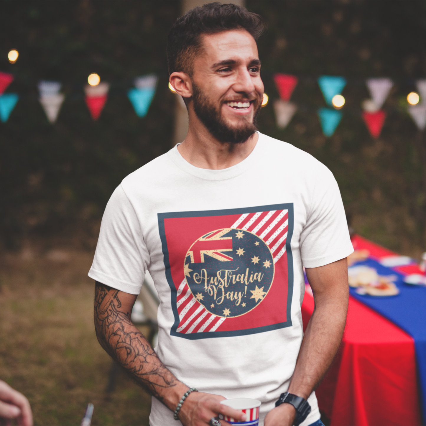 Man wearing a 'Australian Day' t-shirt at an outdoor event with a table and decorations.