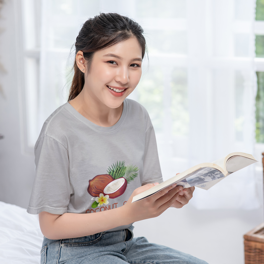 Woman reading a book in a bright room with a neutral background