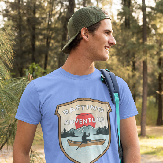 Man wearing a blue t-shirt with a rafting adventure graphic in a forest setting