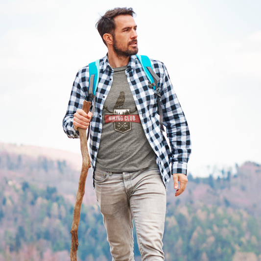 Man hiking with a backpack and walking stick in a mountainous area