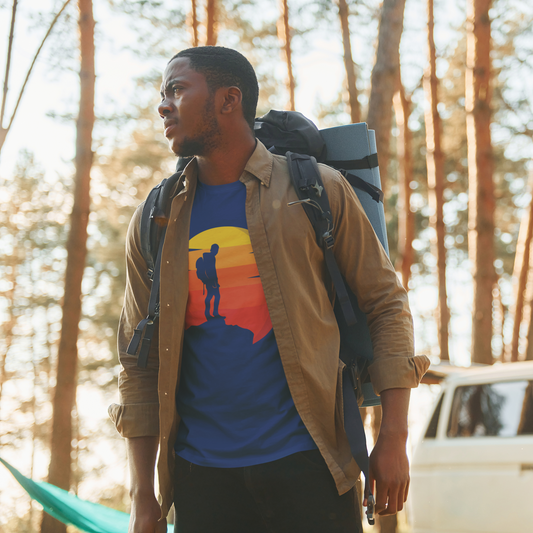 Man with a backpack and colorful shirt standing in a forest