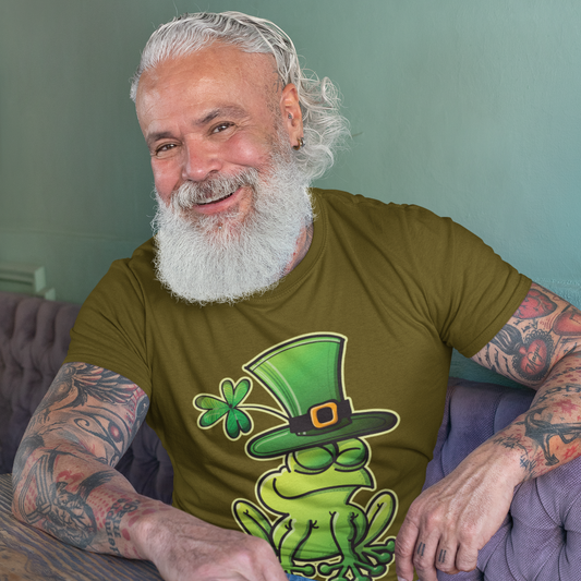 Man sitting on a couch wearing a green t-shirt with a frog and hat graphic.